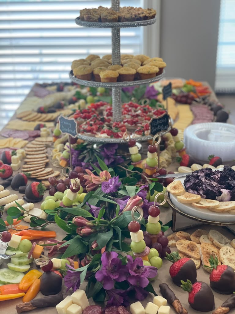 Grazing table spread with mini muffins, strawberries and florals